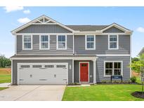 Charming two-story home with a two-car garage, red door, and manicured lawn at 220 Rosewood Dr, Sanford, NC 27330
