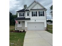 Charming two-story home with a two-car garage, white siding, and an American flag at 224 Wild Turkey Way, Lillington, NC 27546