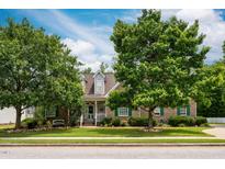 Charming brick home with a well-manicured lawn and mature trees providing shade and curb appeal at 229 Hocutt Farm Dr Dr, Clayton, NC 27527