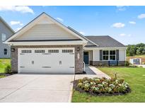 Charming new construction home featuring a two-car garage, stone accents, and beautifully landscaped front yard at 30 Elmwood Ave, Sanford, NC 27330