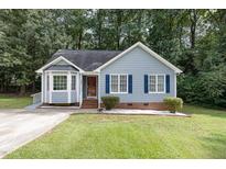 Charming single-Gathering home with blue siding, landscaped yard, and classic architectural details at 5008 Dantonville Ct, Knightdale, NC 27545
