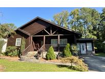 Charming log home with a welcoming front porch and well-maintained landscaping at 603 Hugo St, Durham, NC 27704