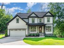 Charming two-story home featuring a manicured lawn, covered entry, and attached two car garage at 66 Sweet Meadow Ln, Pittsboro, NC 27312