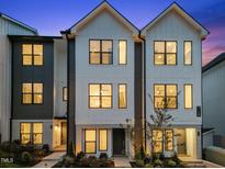 Modern townhome featuring black trim, light brick accents, and a beautifully landscaped front yard at 710 W North St # 101, Raleigh, NC 27603