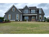 Charming home with a well-maintained lawn and inviting covered porch with decorative wooden shutters at 80 Water Willow Ln, Zebulon, NC 27597