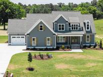 Charming two-story home with a well-manicured lawn and a large two-car garage at 80 Water Willow Ln, Zebulon, NC 27597