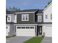 Charming townhome featuring a gray and white exterior, brick accents, and a two-car garage at 8937 Kennebec Crossing Dr, Angier, NC 27501