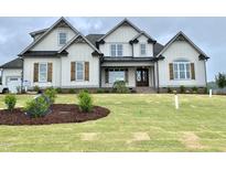 Stunning two-story home featuring beautiful wood shutters, a manicured lawn and meticulous landscaping at 90 Water Willow Ln, Zebulon, NC 27597