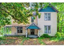 Charming two-story home with a covered porch and mature trees in a residential neighborhood at 903 Nicholas St, Henderson, NC 27536