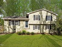 Charming split-level home with a well-manicured lawn and mature trees providing ample shade at 1195 Champion Dr, Cary, NC 27511