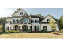 Charming two-story home with stone accents, black shutters, manicured lawn, and a welcoming front porch at 1475 Sierra Glen Cir, Apex, NC 27502