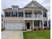 Two-story home boasts a charming front porch, a two-car garage, and a well-manicured lawn at 212 Augusta Pond Way # 128, Raleigh, NC 27603