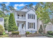 Charming two-story home featuring a double porch, black shutters, and landscaped front yard at 2204 Bellaire Ave, Raleigh, NC 27608