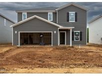 New two-story home with gray siding, open garage and unfinished landscaping at 2250 Cherry Creek Rd, Haw River, NC 27258