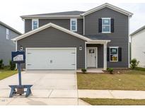 Two-story home featuring a white garage door, grey siding, black shutters, and a well-maintained lawn at 2250 Cherry Creek Rd, Haw River, NC 27258