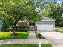 Charming blue home with a well-manicured lawn, landscaped yard, and a two-car garage at 2313 Filigree Ct, Raleigh, NC 27614