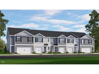New townhomes feature charming exteriors, individual garages, and well-manicured lawns under a bright, sunny sky at 545 Stream Walk Xing, Wendell, NC 27591