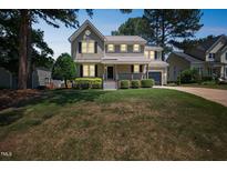 Charming two-story home with a well-manicured lawn and inviting front porch at 5505 Pennfine Dr, Raleigh, NC 27610