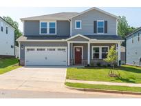 Charming two-story home featuring a two-car garage, covered porch, and well-manicured lawn at 713 Deschutes Dr, Garner, NC 27529