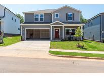 Charming two-story home with gray siding, a well-manicured lawn, and an attached two-car garage at 713 Deschutes Dr, Garner, NC 27529