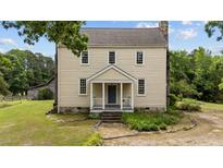 Charming two-story historic home featuring a welcoming front porch and well-maintained landscaping at 7404 Halifax Rd, Youngsville, NC 27596