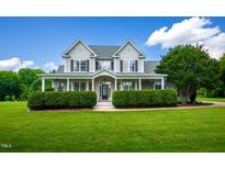 Charming two-story home featuring a large front yard and covered porch perfect for relaxing at 80 Shambley Meadows Dr, Pittsboro, NC 27312