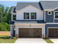 Charming two-story townhome features a large garage and a mix of white and blue siding at 1027 Winding Spring Dr, Mebane, NC 27302