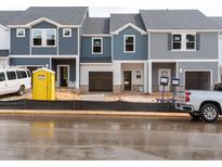 New townhomes with attached garages are under construction, featuring mixed siding and dark grey roofs at 1031 Winding Spring Dr, Mebane, NC 27302