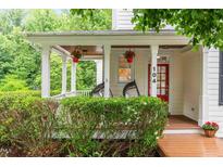 Charming front porch with hanging flower baskets and egg chairs welcomes you home at 104 Edgewater Cir, Chapel Hill, NC 27516