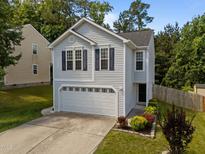 Charming home featuring a two-car garage, updated windows with blue shutters, and professionally landscaped front yard at 109 Gladstone Dr, Durham, NC 27703
