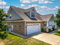 A two-story home with brick and shingle siding with an attached two car garage and manicured lawn at 1218 Crystalwater Dr, Fuquay Varina, NC 27526