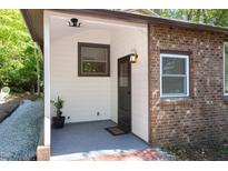 Charming entrance with a brick accent wall, a small window, and a secure black door at 126 Barclay Rd, Chapel Hill, NC 27516