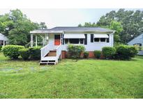 Charming single-story home with white siding, orange door, and well-maintained front yard at 2006 N Ashland Dr, Burlington, NC 27217