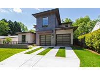 Contemporary home featuring a stylish facade, two-car garage with glass doors, and a well-manicured lawn with striped driveway at 2805 Van Dyke Ave, Raleigh, NC 27607