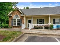 Charming townhome with stone accents, gray roof, and white picket fence offering curb appeal at 320 Madres Ln, Morrisville, NC 27560