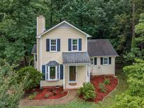 Charming two-story home with a landscaped yard, bay window, and mature trees at 4009 Olde Coach Rd, Durham, NC 27707