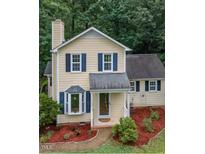 Charming two-story home with manicured landscaping, featuring a bay window and inviting front porch at 4009 Olde Coach Rd, Durham, NC 27707