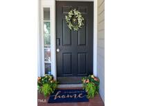 Charming home features a black front door adorned with a wreath and welcome mat at 4905 Knightsbridge Way, Raleigh, NC 27604