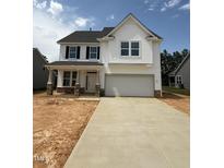 Charming two-story home with white siding, black shutters and a two car garage and long driveway at 516 Winding Creek Dr, Lillington, NC 27546