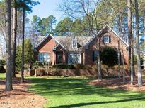 Charming brick home featuring lush landscaping and mature trees adding to its curb appeal at 5401 Fire Pink Way, Raleigh, NC 27613