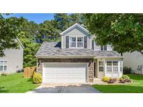 Home featuring a two-car garage, stone accents, and a well-manicured lawn at 6 Beaver Creek Lane Ln, Durham, NC 27703
