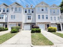 Beautiful townhouses with a well-manicured lawn and individual driveways on a sunny day at 650 Ganyard Farm Way # 41, Durham, NC 27703