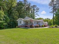 Charming single-story home with a well-maintained lawn and a cozy front porch at 707 Lakewood Dr, Siler City, NC 27344