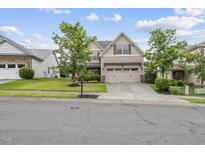 Charming two-story home with a two car garage, well maintained lawn, and mature trees at 817 Ember Dr, Durham, NC 27703