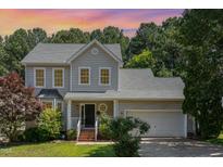Charming two-story home boasts a well-maintained lawn, attached garage, and beautiful landscaping at 8512 Erinsbrook Dr, Raleigh, NC 27617