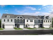 Charming townhome showcases a well-maintained front exterior with a two car garage and manicured landscaping at 8732 Wardle Ct, Wake Forest, NC 27587