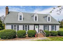 Charming two-story home with gray siding, dormer windows, brick chimney, and a well-manicured front yard at 110 W Quail Ridge Rd, Oxford, NC 27565