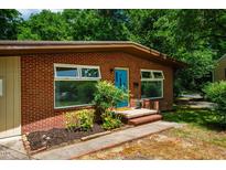 Charming brick home exterior with a bright blue front door and manicured landscaping at 112 Noble St, Chapel Hill, NC 27516