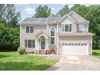 Charming two-story home with manicured lawn, attached garage, and a welcoming teal front door at 113 Paladin Place, Cary, NC 27513
