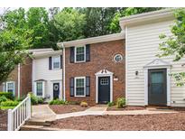 Charming townhome with brick facade, black shutters, and meticulously landscaped front yard at 129 Assembly Ct, Cary, NC 27511